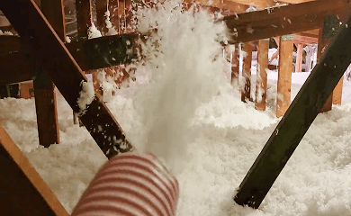 Insulation is being sprayed into an attic.