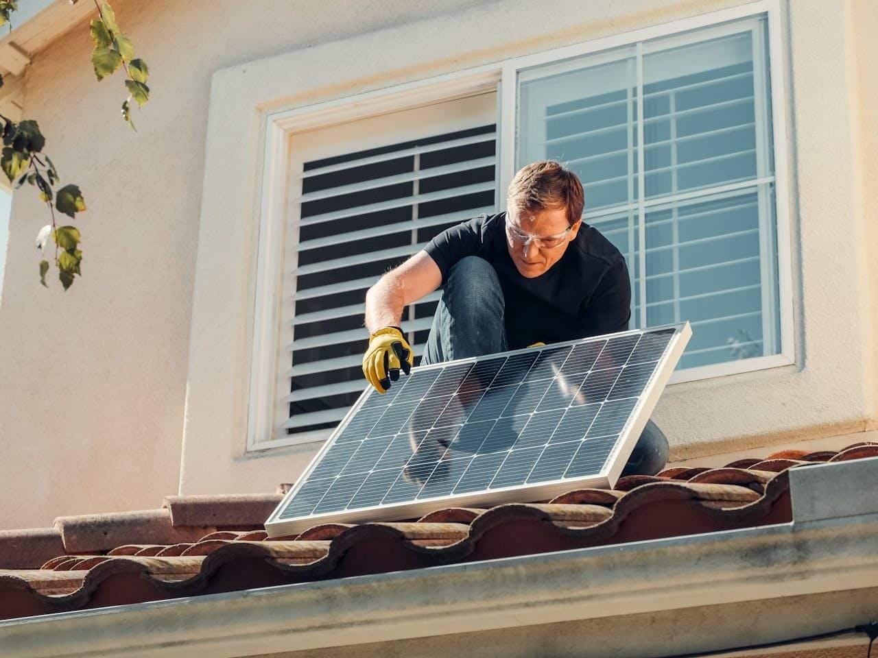 A person installing a solar panel on a roof.