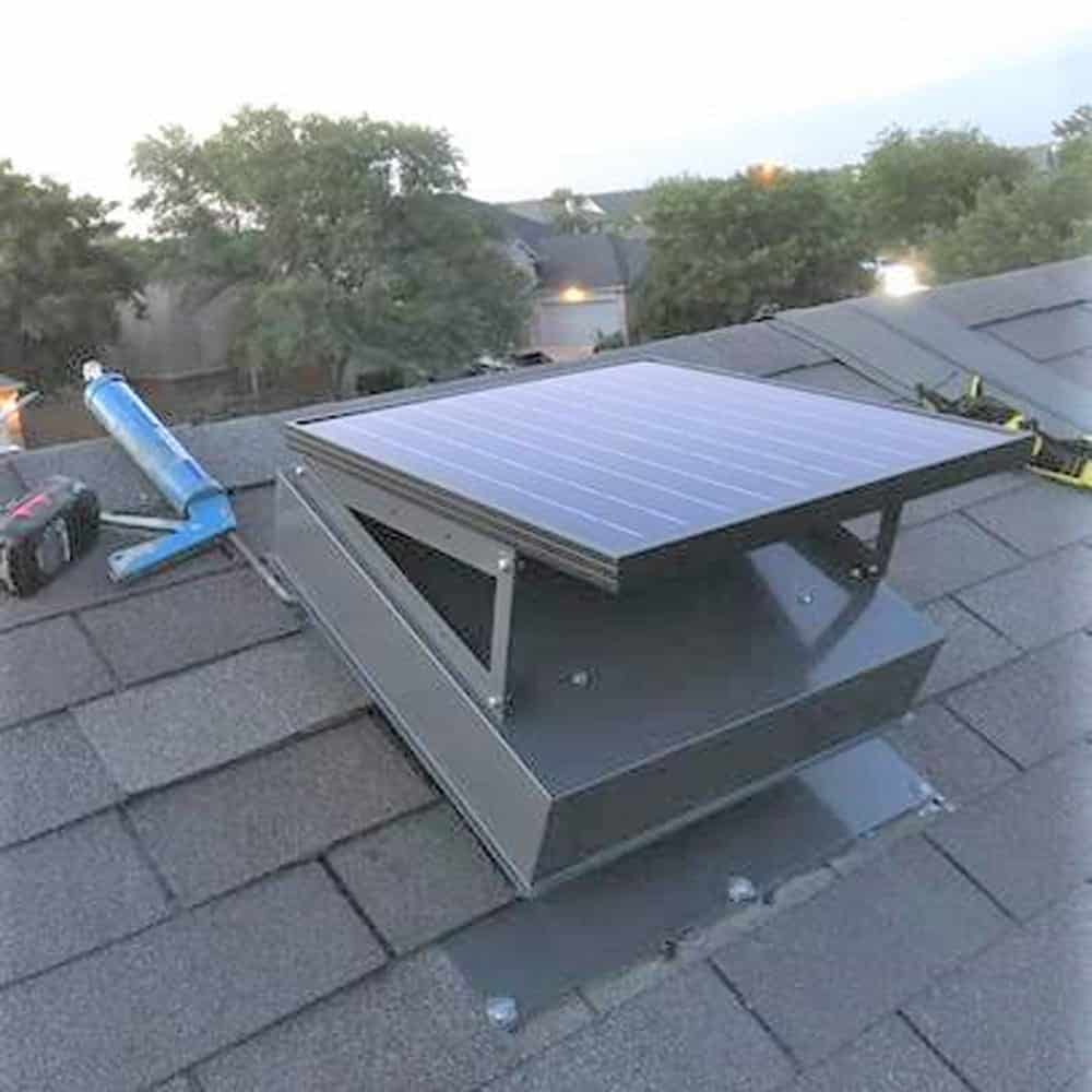 A Remington Solar attic fan being installed on a roof.
