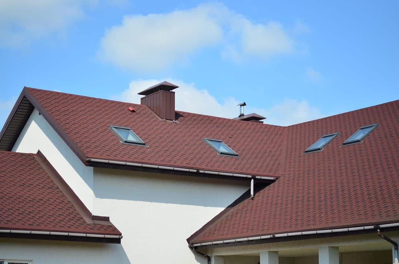 A roof with several windows and red shingles.